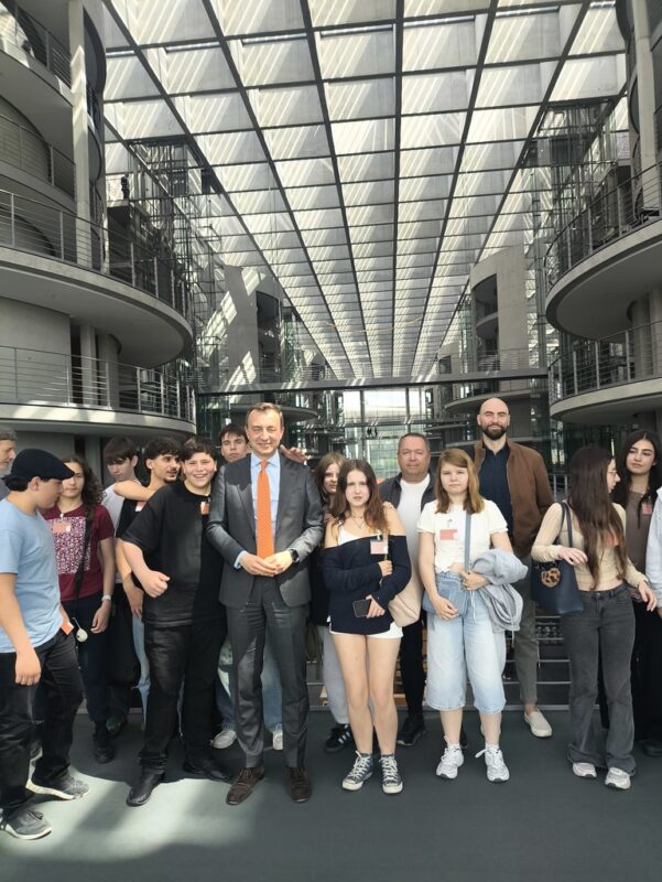 Uczniowie TME z politykiem CDU i opiekunami w holu Bundestagu pod szklanym dachem