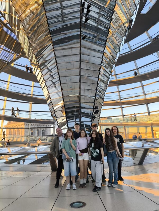 Uczniowie TME i opiekun wewnątrz szklanej kopuły Reichstagu z centralnym lustrzanym stożkiem